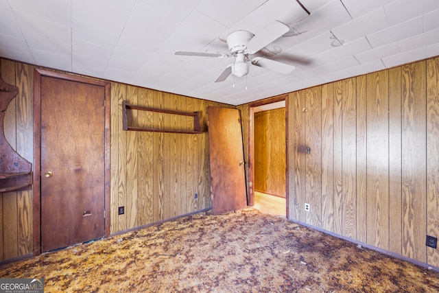 unfurnished bedroom featuring wooden walls and carpet floors