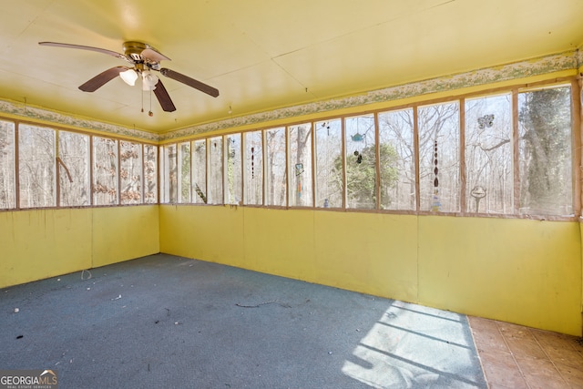 unfurnished sunroom with a ceiling fan