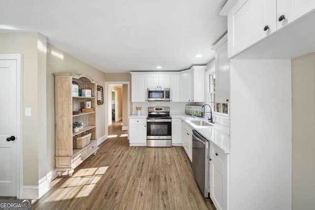 kitchen featuring a sink, backsplash, light countertops, stainless steel appliances, and open shelves