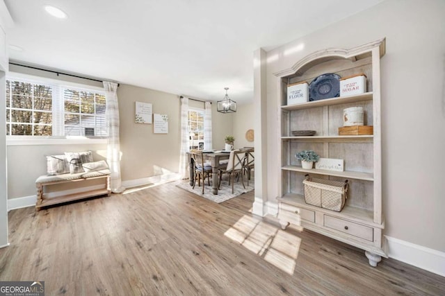 dining room featuring an inviting chandelier, baseboards, and wood finished floors