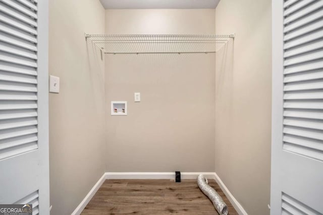 clothes washing area featuring laundry area, hookup for a washing machine, wood finished floors, and baseboards