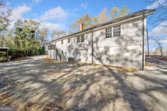 back of property with stairs and a chimney