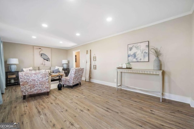 living area with crown molding, baseboards, and wood finished floors