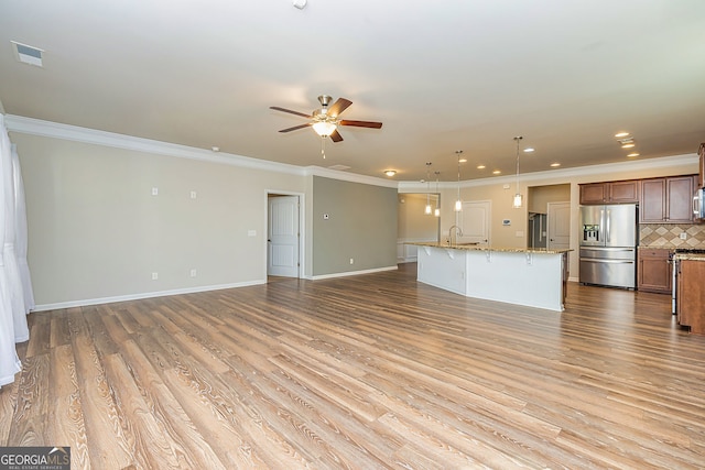 unfurnished living room featuring a ceiling fan, crown molding, wood finished floors, and visible vents