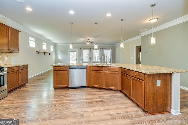 kitchen featuring light wood-type flooring, brown cabinets, a sink, stainless steel appliances, and crown molding