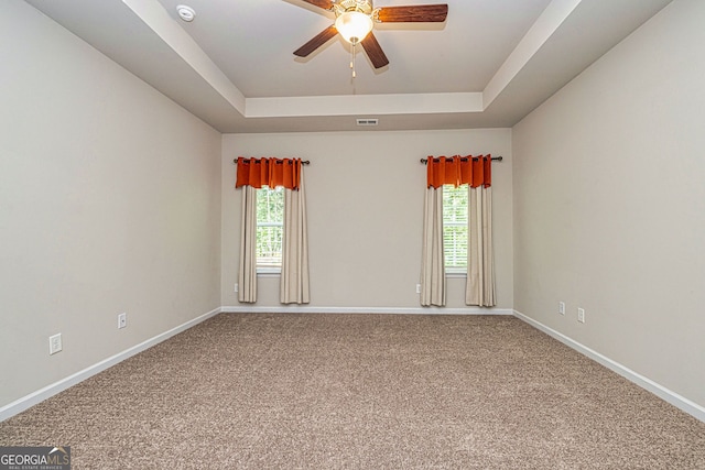 4 October Ave, Newnan, GA 30265 - spare room featuring a tray ceiling, carpet flooring, ceiling fan, and healthy amount of natural light