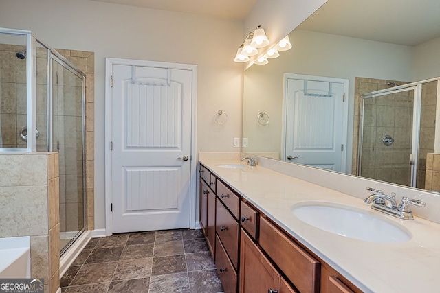 bathroom with a sink, a stall shower, and double vanity