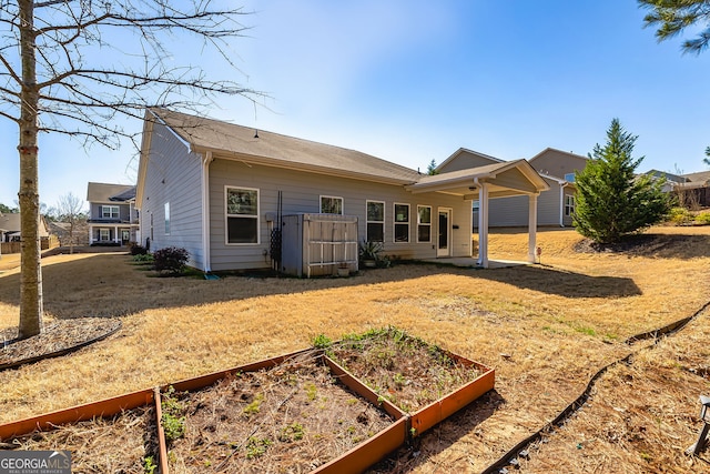 rear view of property with a lawn and a garden