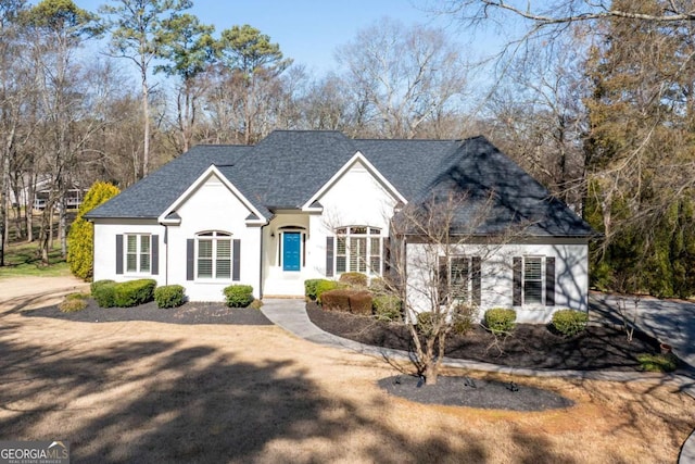 view of front of house featuring stucco siding and roof with shingles