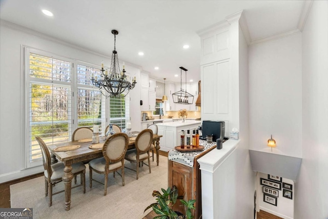 dining room featuring light wood finished floors, crown molding, baseboards, a chandelier, and recessed lighting