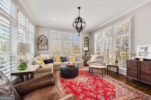 living area with a wealth of natural light, a notable chandelier, wood finished floors, and crown molding