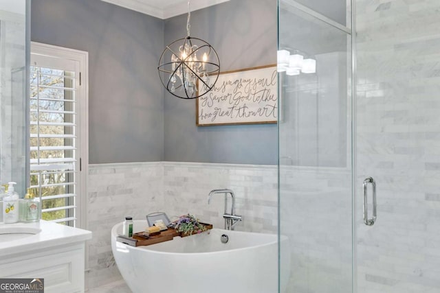 full bath with crown molding, vanity, a stall shower, a soaking tub, and tile walls