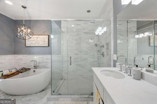 full bathroom featuring vanity, a freestanding bath, a shower stall, tile walls, and marble finish floor