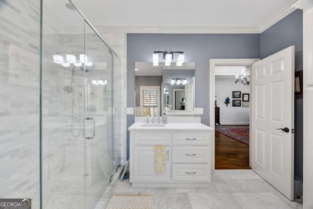 bathroom with a notable chandelier, a shower stall, vanity, and ornamental molding