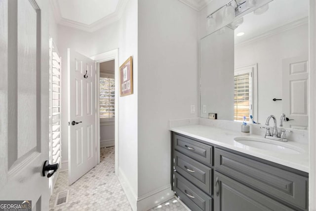 bathroom featuring visible vents, baseboards, ornamental molding, and vanity