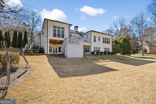 back of property with stairway, a yard, and stucco siding