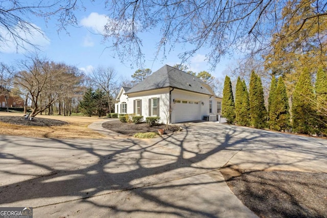 view of property exterior with stucco siding, an attached garage, and concrete driveway