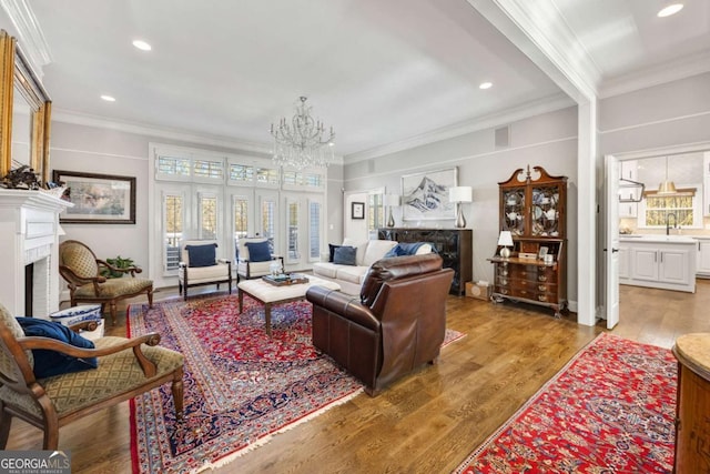 living area with light wood-type flooring, a fireplace, and crown molding