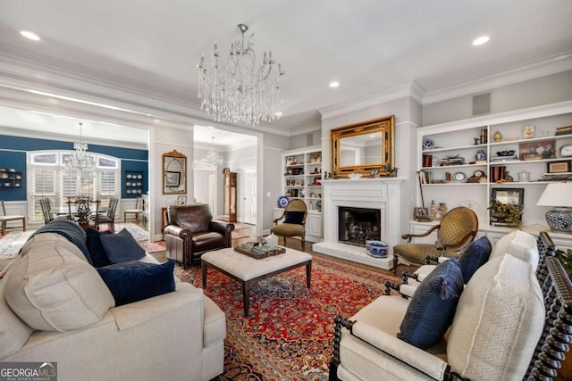 living area featuring a brick fireplace, crown molding, built in features, recessed lighting, and an inviting chandelier