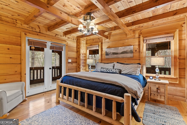 bedroom with access to exterior, wooden walls, and light wood finished floors