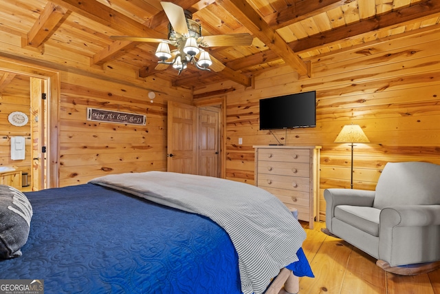 bedroom with wooden walls, beamed ceiling, light wood-type flooring, wooden ceiling, and a ceiling fan