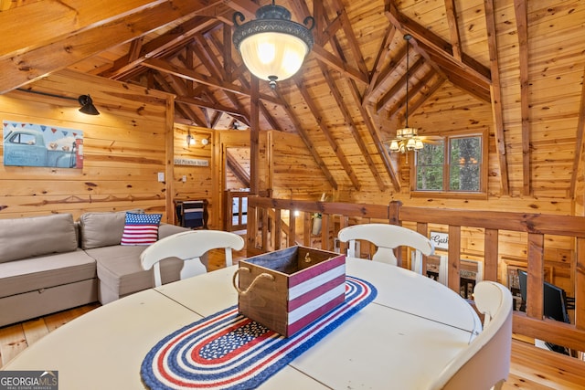 dining room with wood finished floors, wood ceiling, wood walls, and vaulted ceiling with beams