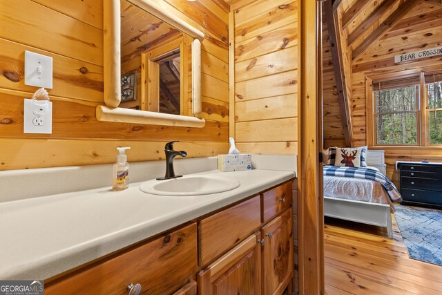 bathroom featuring wooden walls, wood finished floors, and vanity