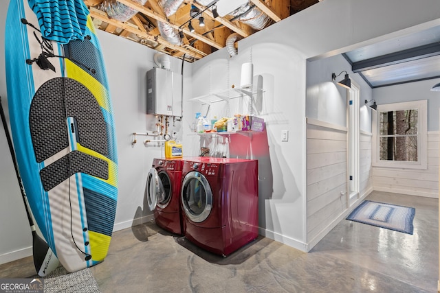 laundry area featuring baseboards, water heater, and washer and clothes dryer