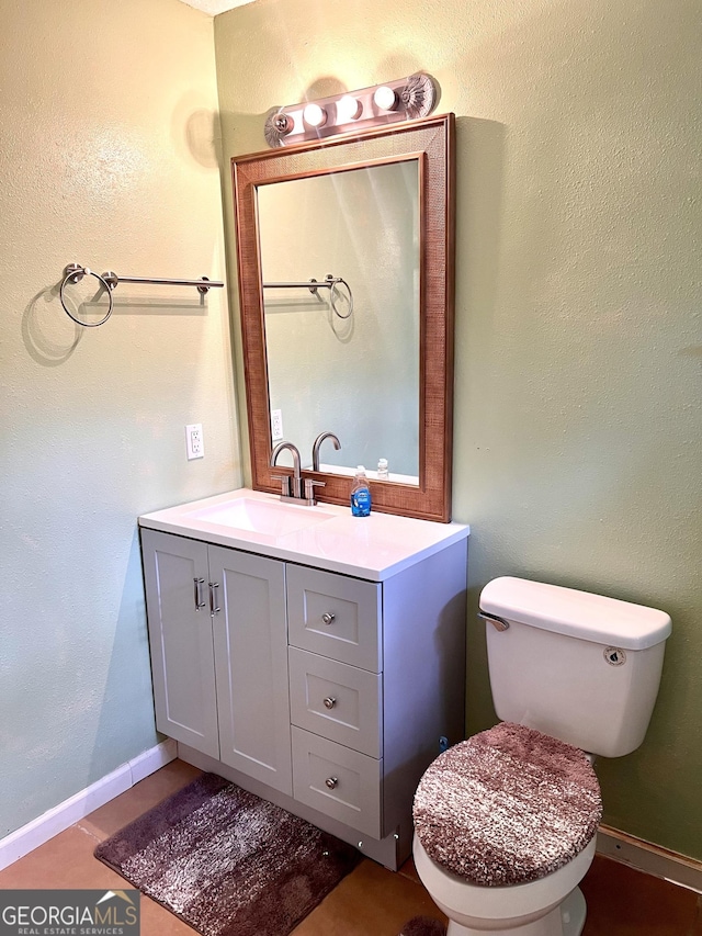 bathroom featuring baseboards, toilet, and vanity