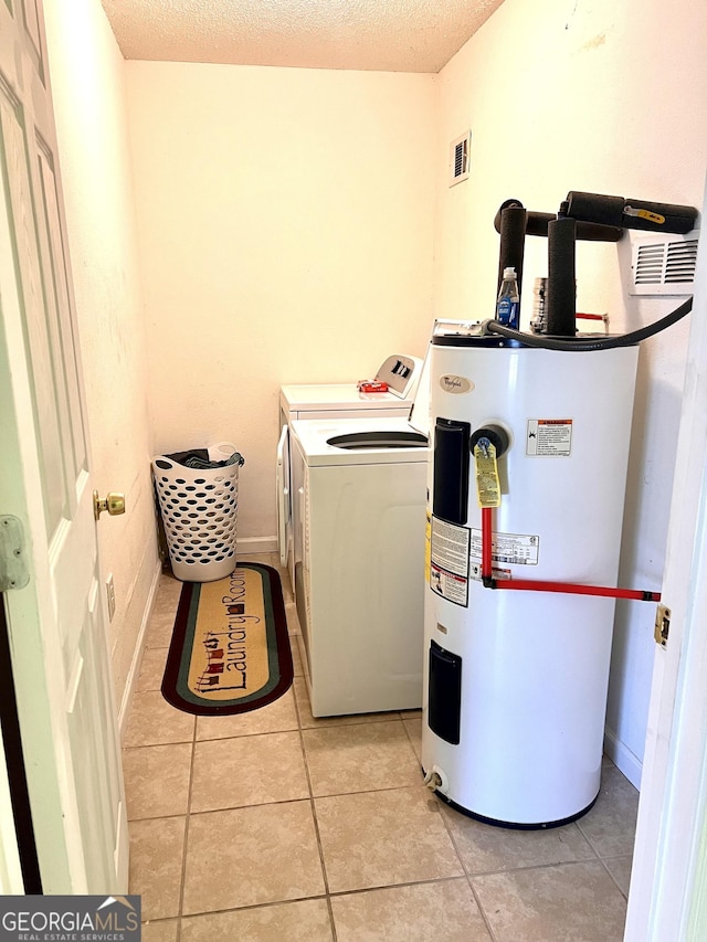 laundry area with light tile patterned floors, visible vents, laundry area, a textured ceiling, and electric water heater