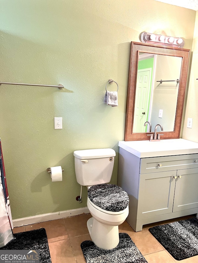 bathroom featuring tile patterned floors, toilet, vanity, and baseboards