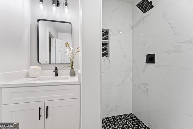 bathroom with a marble finish shower and vanity