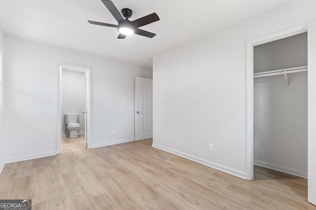 unfurnished bedroom featuring baseboards, light wood-style flooring, ensuite bathroom, a closet, and a ceiling fan