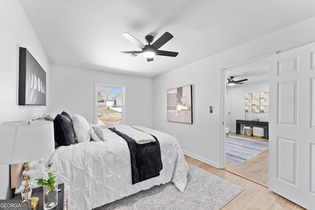 bedroom featuring ceiling fan, baseboards, and light wood-style floors