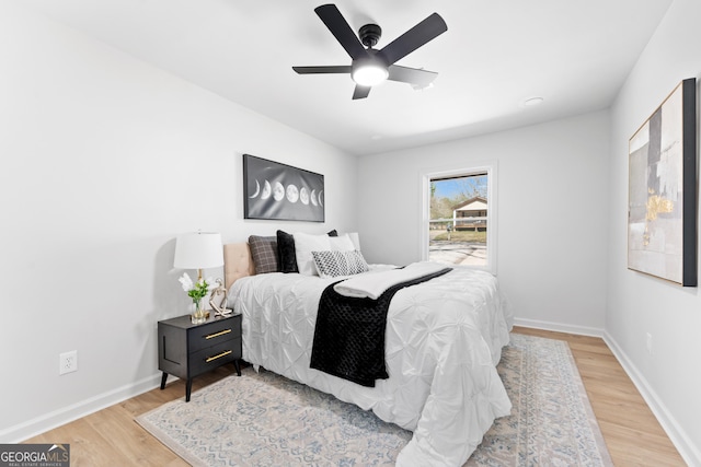 bedroom featuring light wood-style floors, baseboards, and ceiling fan