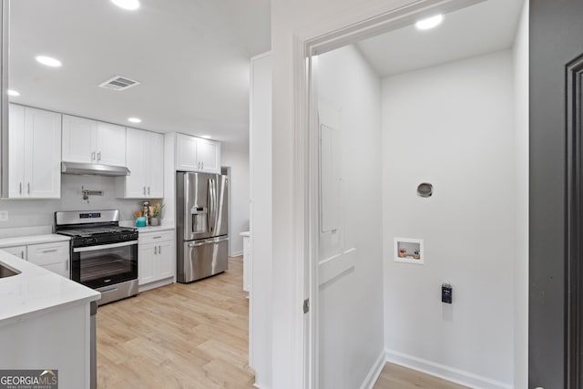 kitchen featuring white cabinets, visible vents, under cabinet range hood, and stainless steel appliances