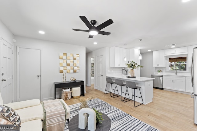 living room featuring a ceiling fan, light wood-style flooring, recessed lighting, and baseboards