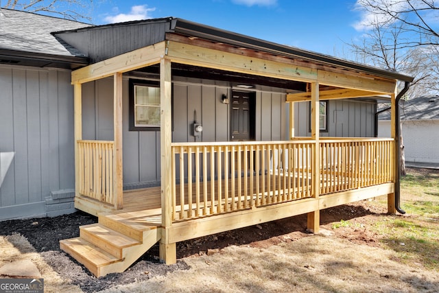 property entrance featuring board and batten siding and roof with shingles