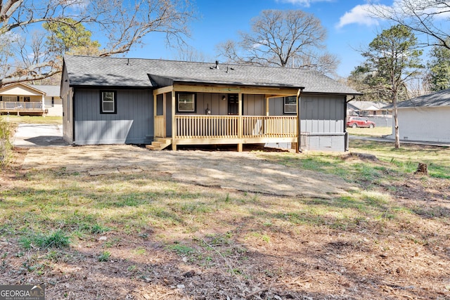 back of house featuring board and batten siding and a shingled roof