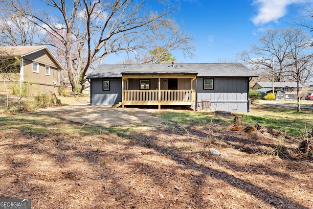 rear view of property featuring roof with shingles and board and batten siding