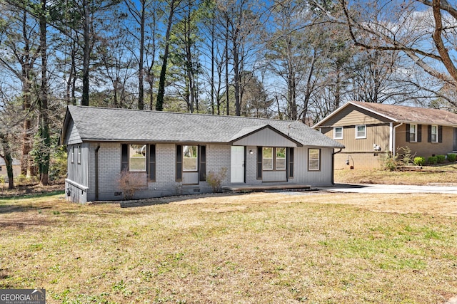 ranch-style home with crawl space, a front lawn, brick siding, and roof with shingles