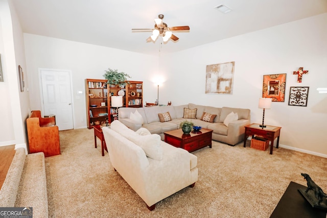 carpeted living room featuring visible vents, baseboards, and a ceiling fan