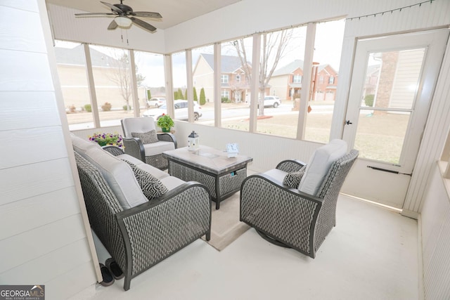 sunroom / solarium with a residential view and ceiling fan