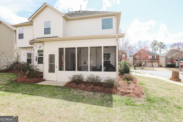 back of property featuring a yard and a sunroom