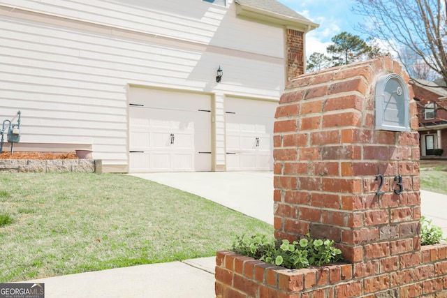 doorway to property with driveway, a shingled roof, a garage, a lawn, and brick siding