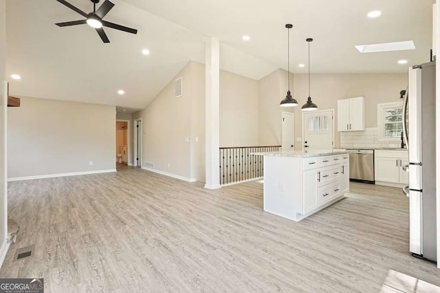 kitchen featuring stainless steel dishwasher, a ceiling fan, open floor plan, and freestanding refrigerator