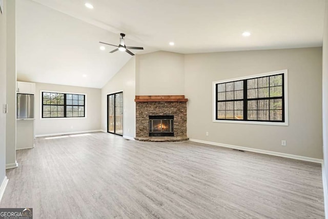 unfurnished living room featuring baseboards, a stone fireplace, recessed lighting, light wood-style floors, and a ceiling fan