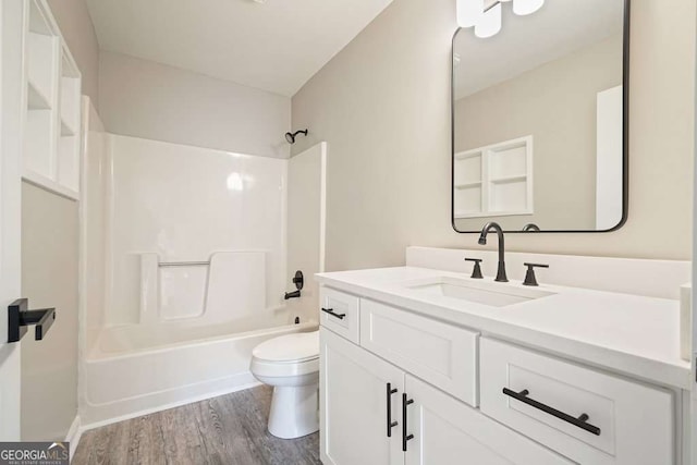 full bathroom featuring vanity, toilet, wood finished floors, and bathtub / shower combination