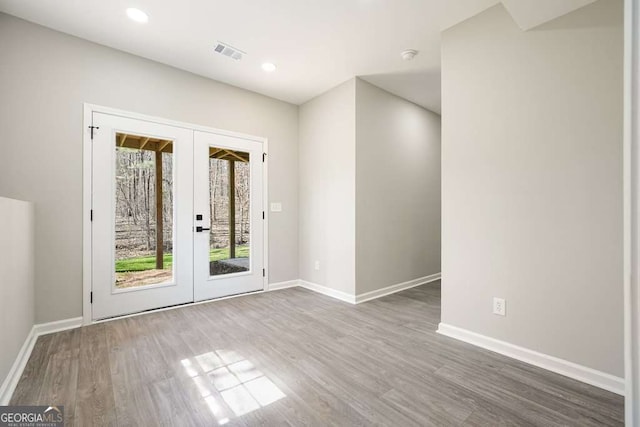 interior space with visible vents, french doors, baseboards, and wood finished floors