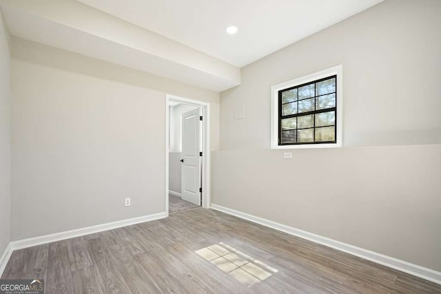 empty room featuring recessed lighting, baseboards, and wood finished floors